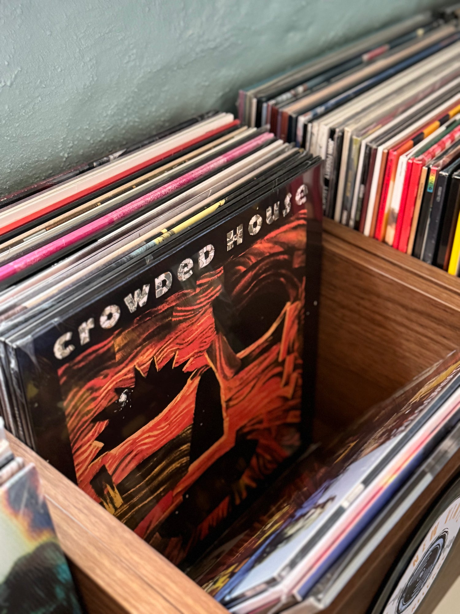 Wooden record tub inside Peninsula Records & Books Stansbury, showing Crowded House ‘Woodface’ vinyl among new releases on the Yorke Peninsula.