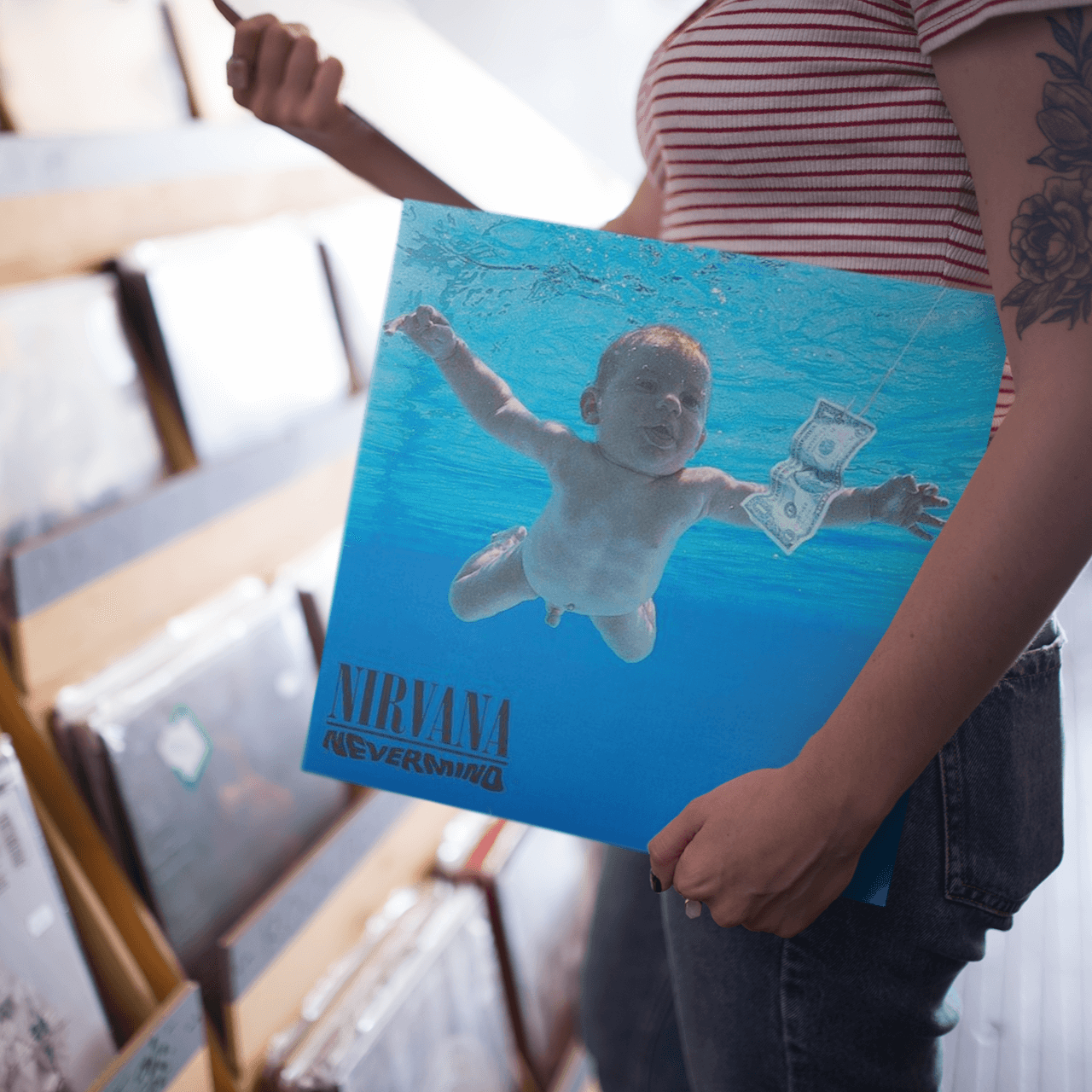 Nirvana Nevermind vinyl LP sleeve being held in a record store punk and indie rock section