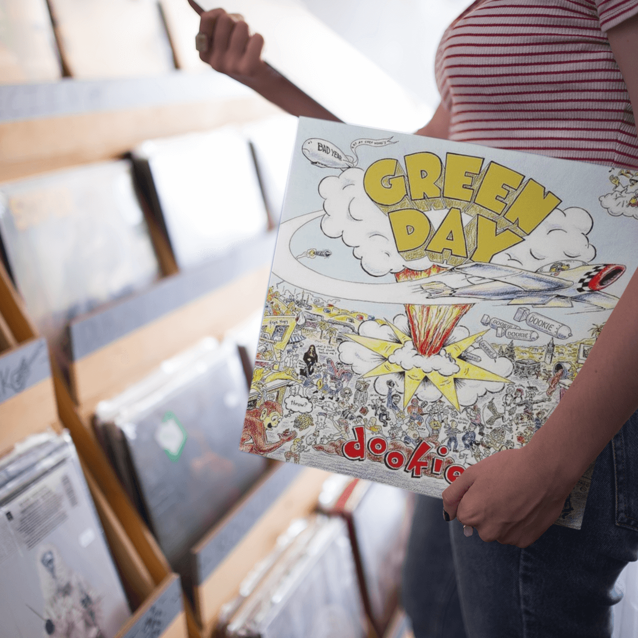 Girl holding a Green Day Vinyl Record in a Record Shop in South Australia