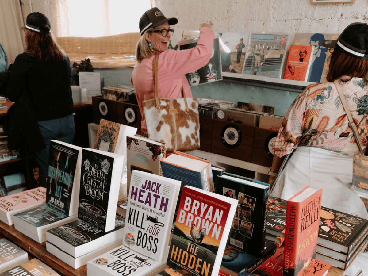Customers browsing new books and vinyl records inside Peninsula Records & Books in Stansbury