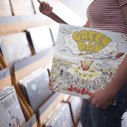 Girl holding a Green Day Vinyl Record in a Record Shop in South Australia